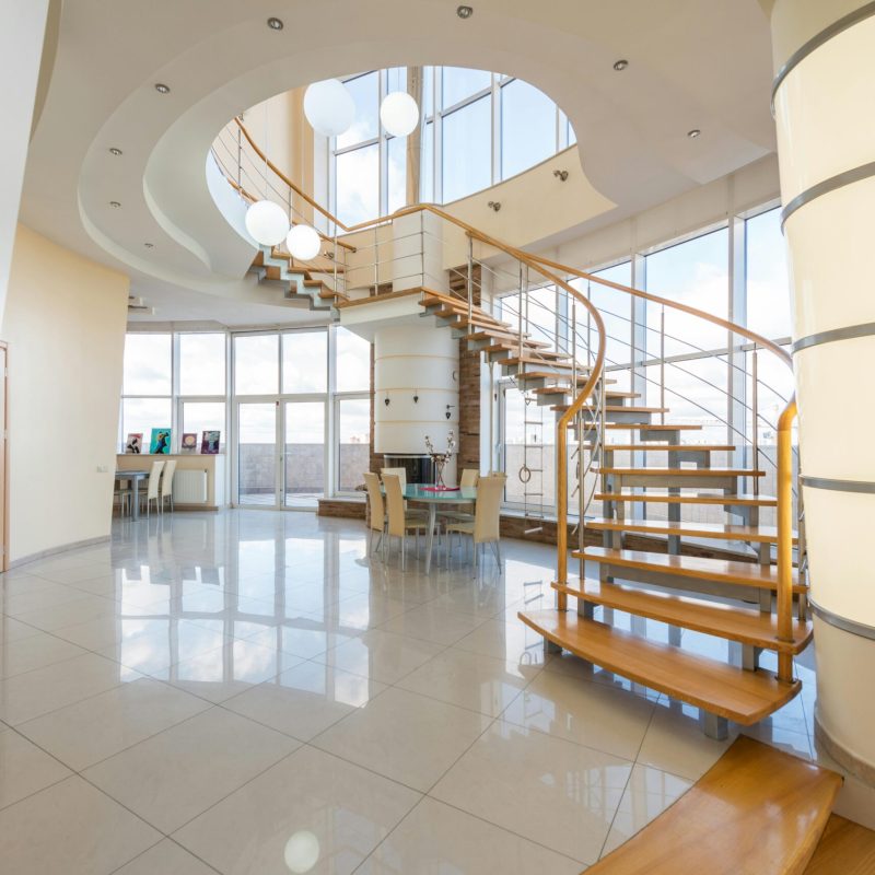 Spacious modern interior featuring elegant spiral staircase and bright lighting.